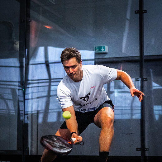 Junger Mann im Court schlägt den Ball von unten